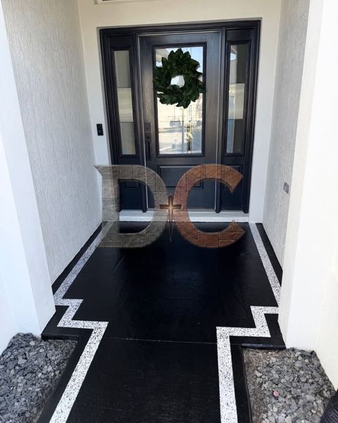 Charcoal coated front entry walkway with a stepped white speckled border