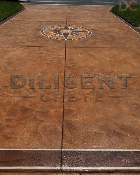 Stamped concrete driveway in copper tones with a compass rose medallion and dark border